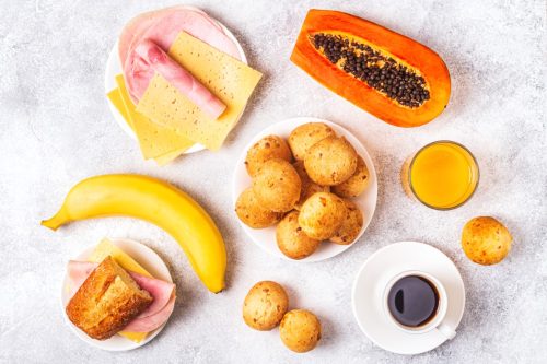 Traditional Brazilian breakfast - cheese bread, coffee, ripe fruit, top view.